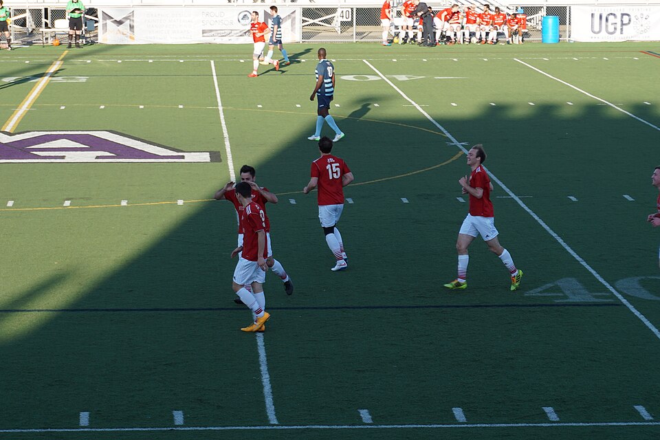 Delantero disputando un balón con un defensa en área rival